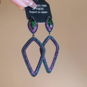 Gros plan détaillé de boucles d'oreilles losanges avec strass rouges et bleus