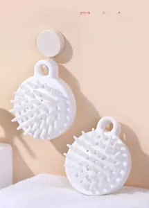 Detail of white silicone scalp massage brush with soft tapered bristles and hanging loop