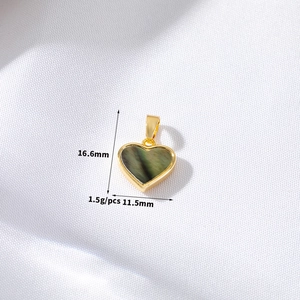 Macro view of 14K gold heart pendant featuring dark shimmering mother of pearl inlay