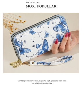 Detail of white butterfly print clutch bag with dual golden zippers and wrist strap