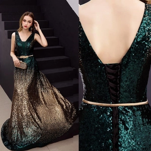 Détail de robe de soirée à paillettes dégradées avec col en V et ceinture feuille métal