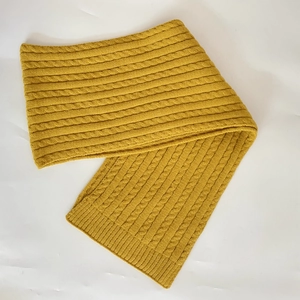 Detail of ginger yellow knitted scarf with premium chunky cable stitch texture