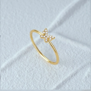 Macro shot of gold silver ring featuring a sparkling diamond butterfly design