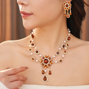 Nahaufnahme von Vintage-Goldhalskette und Perlenohrringen an einem Model