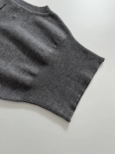 Detailed macro view of the dark grey knit fabric texture with ribbed cuff finish