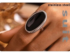 Macro view of a large oval black resin stone set in a polished stainless steel ring