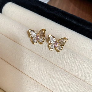 Macro shot of butterfly earrings with 18k gold plating and pink zircon inlay
