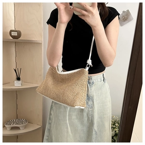 Close-up of straw shoulder bag with white leather straps shown in a mirror selfie
