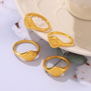 Gold-plated titanium steel rings featuring an engraved sun face design on round signets