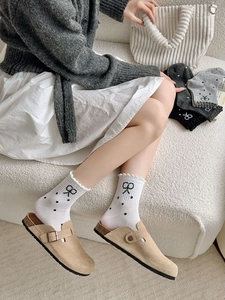 Detail of ruffle cuff socks with bow embroidery and polka dots on a soft knit fabric