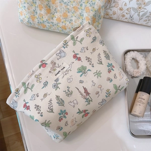 Close-up of floral cosmetic bag with simple wish label and bird prints on cotton fabric