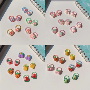 Close-up of colorful resin fruit and animal charms on elastic nylon kids hair ties