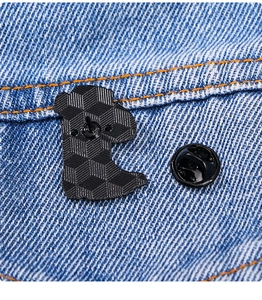 Détail macro du dos de l'insigne métallique avec fermoir papillon sur fond de denim
