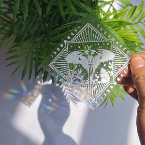 Detailed holographic suncatcher sticker featuring moth and moon phases with light reflections