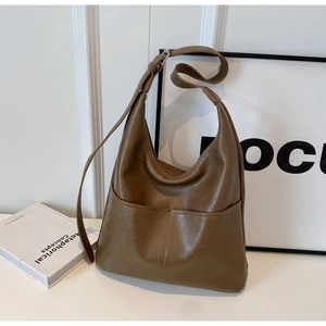 Detail view of the brown soft leather tote bag with external pocket and adjustable strap