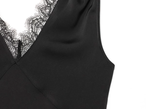 Detail of black silk camisole top featuring delicate eyelash lace trim and thin straps