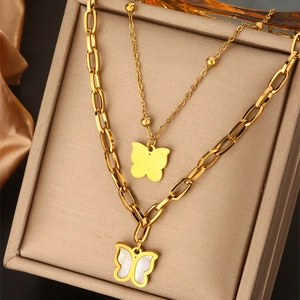 Detail of double-layer gold necklace featuring butterfly pendants and shell inlays