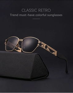Close-up of golden steampunk sunglasses with engraved temples on a black textured case
