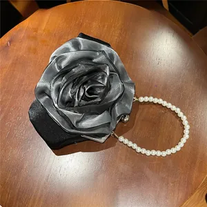 Detail showing 3D black rose fabric texture and pearl handle of the lady evening bag