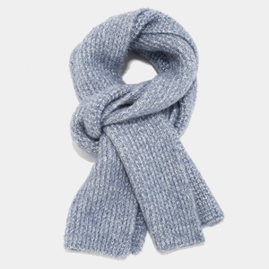 Detail of blue chunky knit scarf texture with soft fringe and stylish knotted design