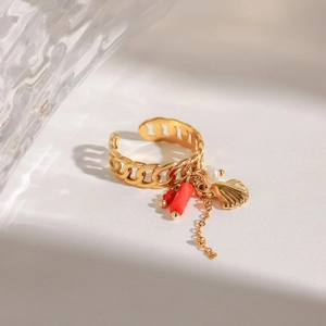 Detail of gold Cuban link ring featuring coral pendant, pearl, and sea shell charm details