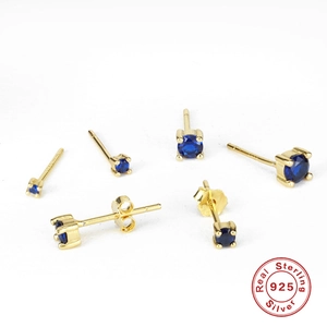 Detail of 925 sterling silver gold-plated stud earrings with blue round-cut stones