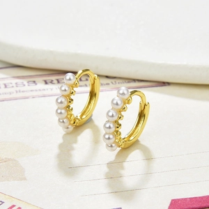 Elegant gold-plated pearl hoop earrings featuring six white pearls in a vintage style