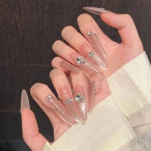 Macro shot of stiletto cat-eye press-on nails with silver rhinestones and pearls