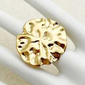 Exaggerated gold stainless steel ring with a hammered texture disk design on a hand model