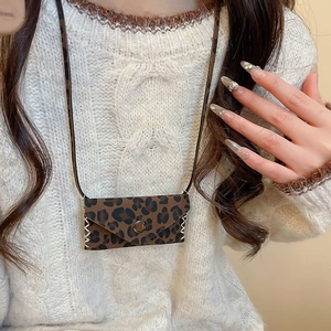 Detail of leopard print leather bag pendant with white whipstitch and metal button