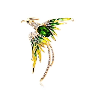 Golden phoenix brooch with green enamel and sparkling rhinestones on white background