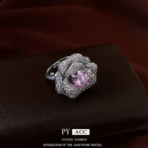 Elegant French flower ring with pink gemstone and zircon petals on a dark leather base