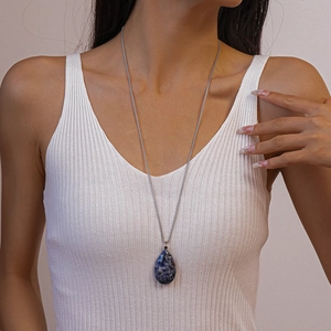 Detail of blue teardrop natural stone pendant on a silver long chain necklace for women