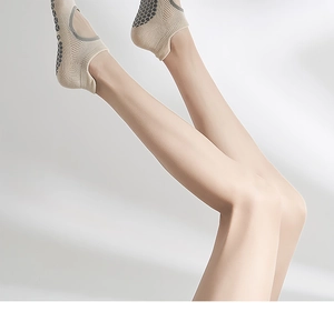 Close-up of cotton yoga socks with non-slip silicone grips on the sole in beige