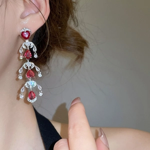 Close-up of sparkling ruby teardrop tassel earrings worn by a model in french style