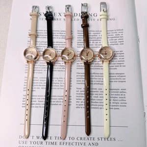 Vertical display of luxury women's quartz watches with assorted colored leather straps on a book