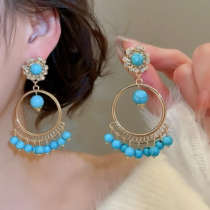 Close-up of bohemian tassel earrings with turquoise beads and sparkling rhinestones