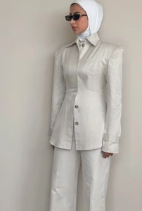 Detailed view of cream tailored blazer with notched lapels and structured shoulder pads