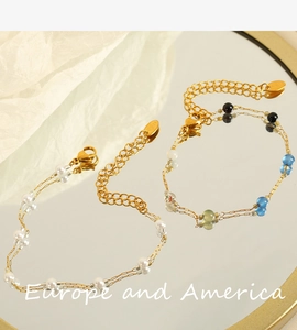 Detail of double-layer gold bracelets with white pearls and colorful beads in mirror view