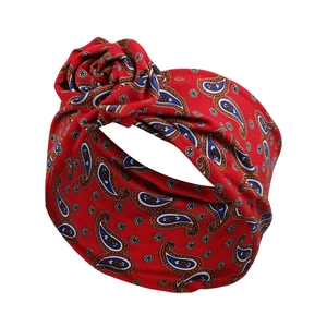 Detail eines roten Haarbandes mit Paisley-Muster und gedrehter Samtrosen-Applikation