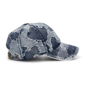 Détail d'une casquette en denim vieilli avec trous vintage et boucle en métal réglable
