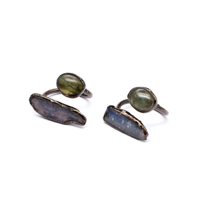 Detail of two vintage handmade copper rings featuring natural raw stones on white background
