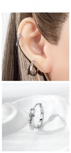 Detail of silver zipper-shaped earrings with zircon accents on a clean white background