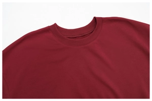 Detailed close-up of the ribbed crew neck and shoulder seam on this maroon cotton hoodie