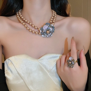 Detail of vintage champagne pearl necklace and matching enamel flower ring set