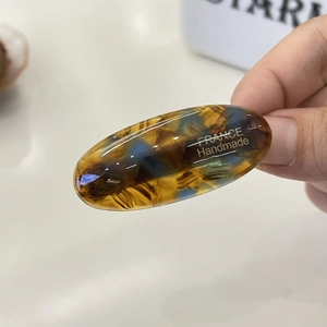 Detail of handmade acetate hair clip with amber and blue tortoiseshell pattern