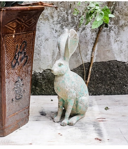 Detailed close-up of rabbit resin sculpture with rustic aged texture and weathered finish