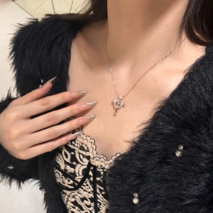 Detail of S925 sterling silver cross heart necklace worn with lace and faux fur coat