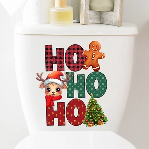 Close-up of HO HO HO Christmas stickers featuring reindeer and gingerbread on a toilet tank