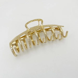 Detailed view of the gold alloy hair claw clip featuring a unique hammered metal texture